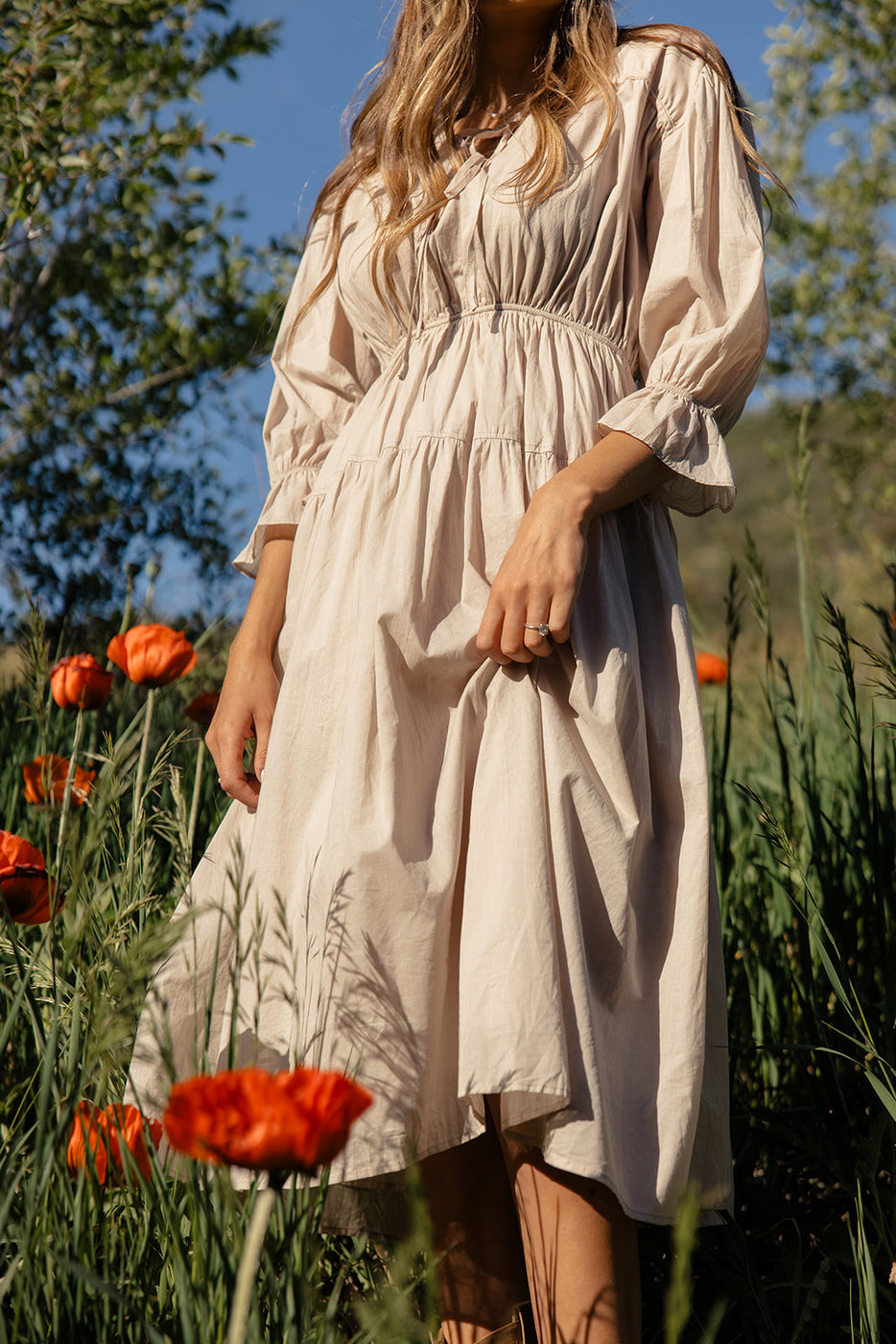 a woman in a dress in a field of flowers