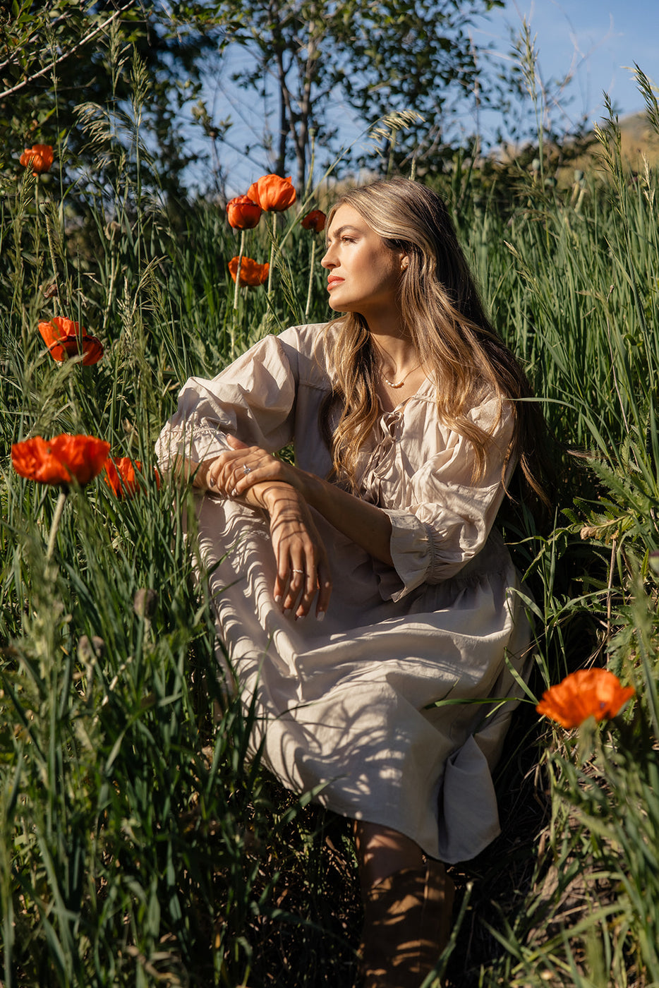 a woman sitting in a field of flowers