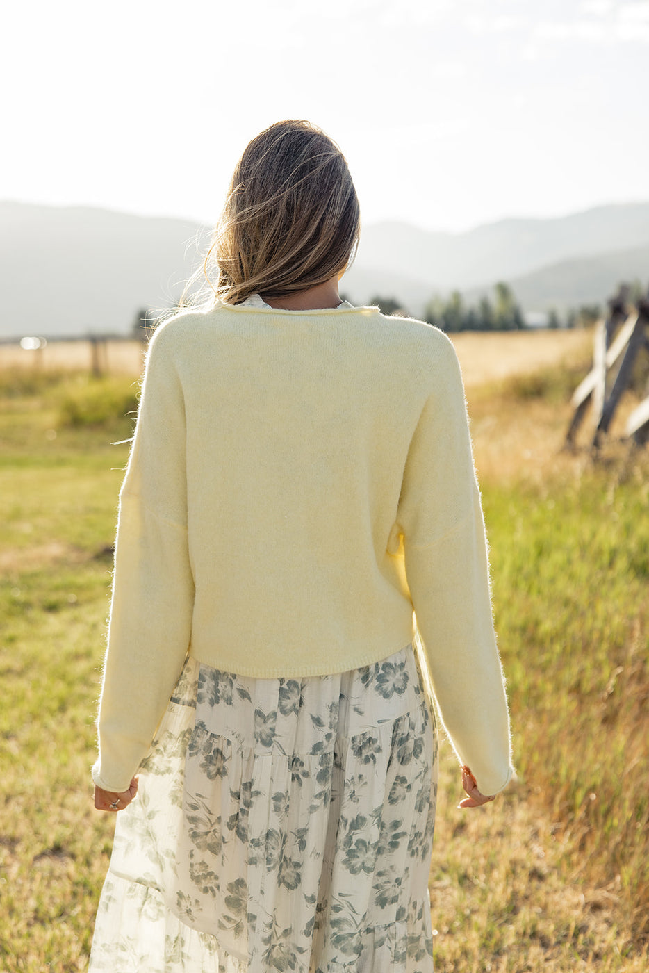 a woman in a white sweater and a white dress