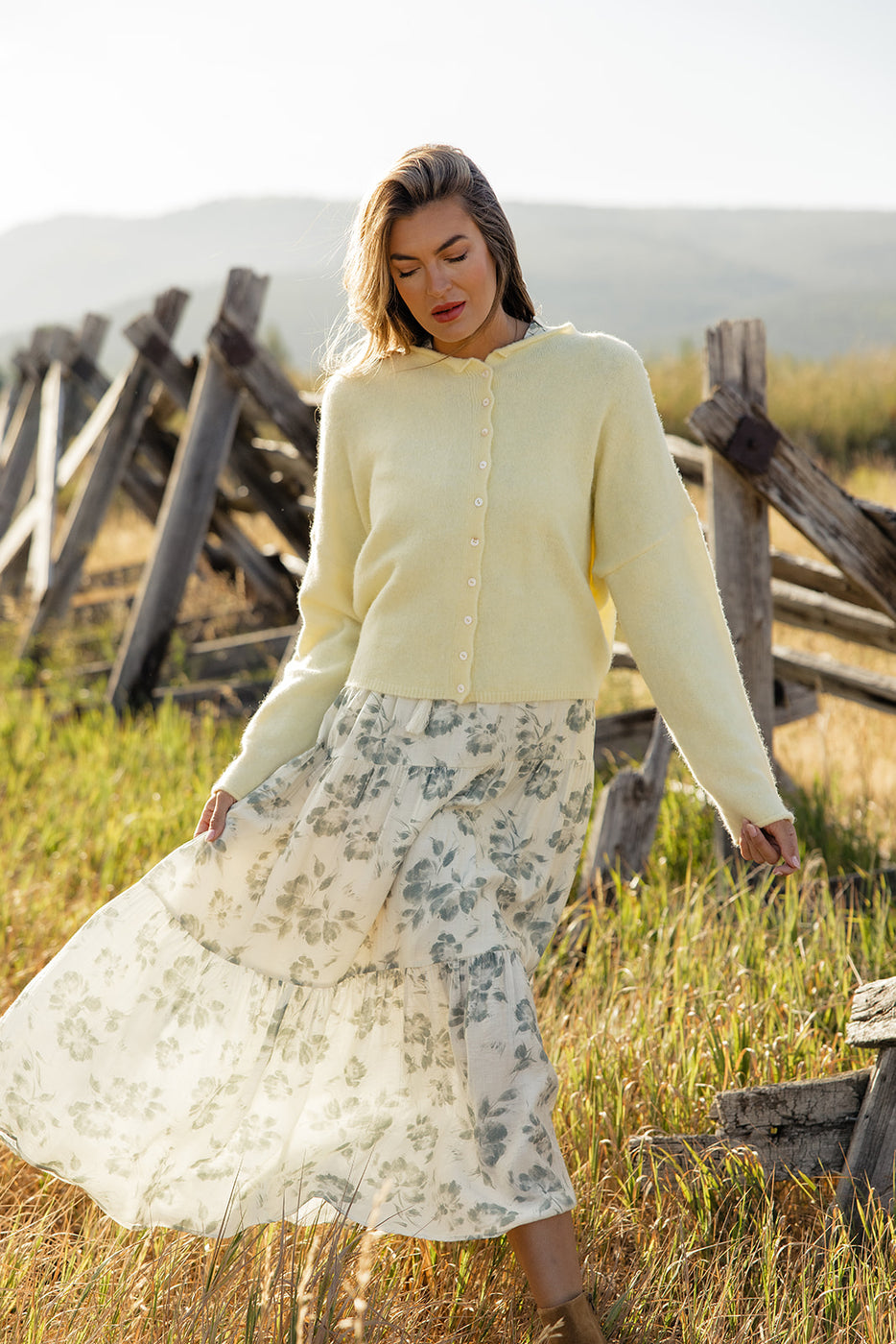 a woman in a long white skirt and a yellow sweater