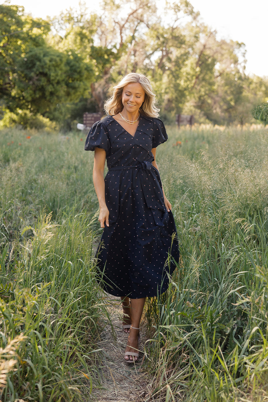 a woman in a dress in tall grass