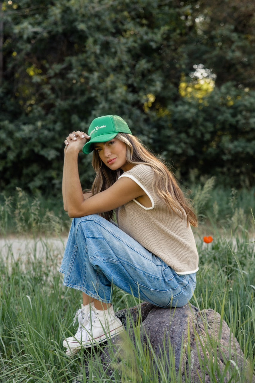 a woman sitting on a rock in tall grass