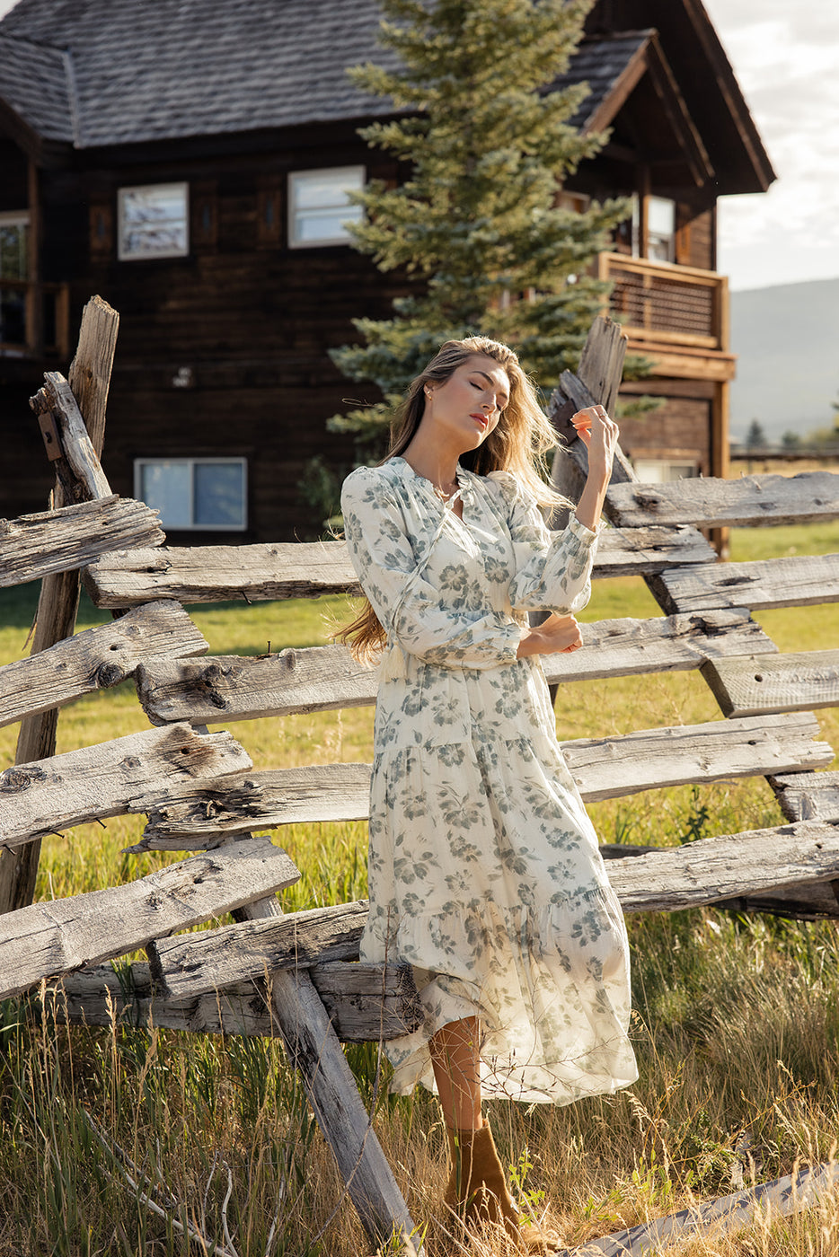 a woman in a white dress standing in front of a wooden fence