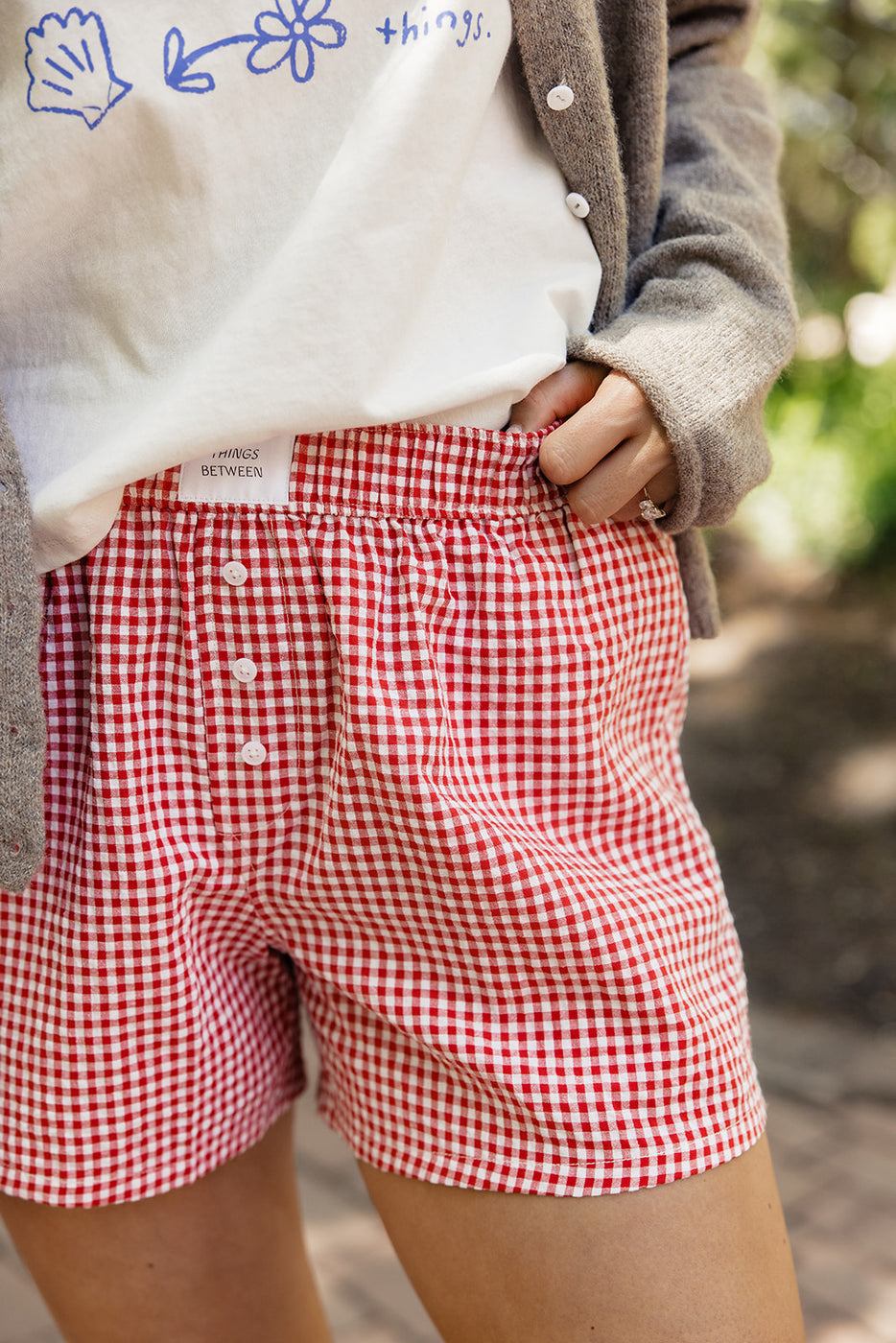 a person wearing red and white checkered shorts