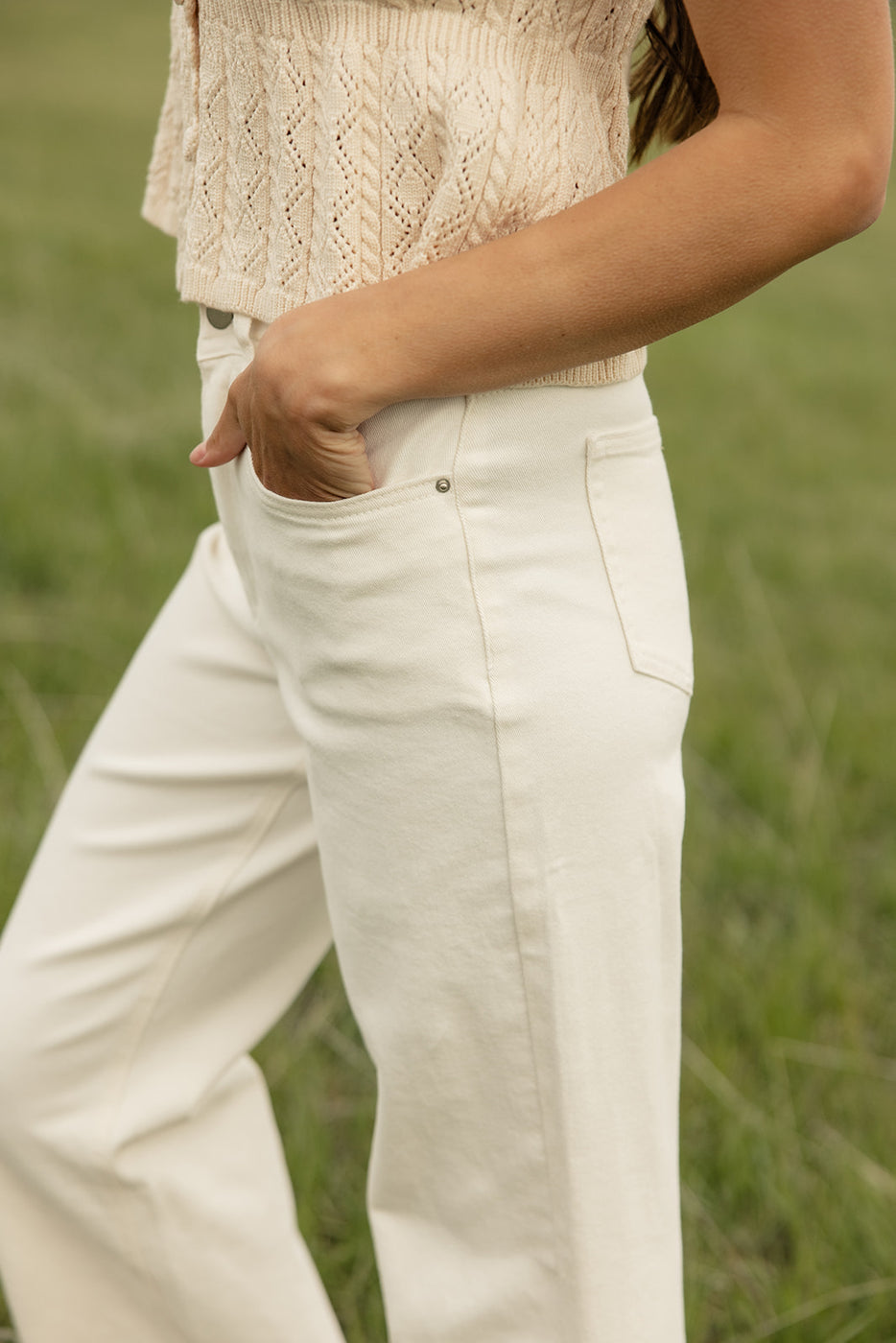 a person in white pants with their hands in their pockets