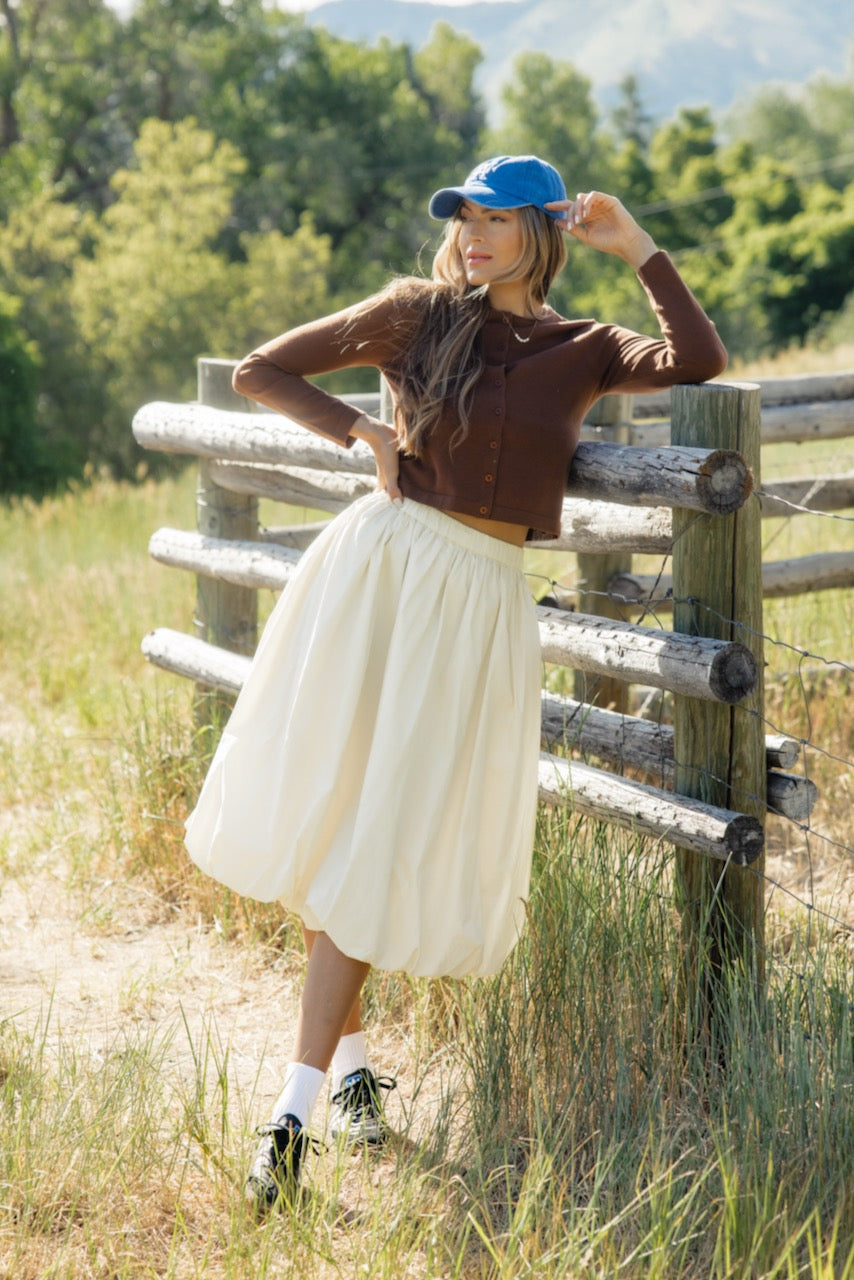 a woman leaning against a fence