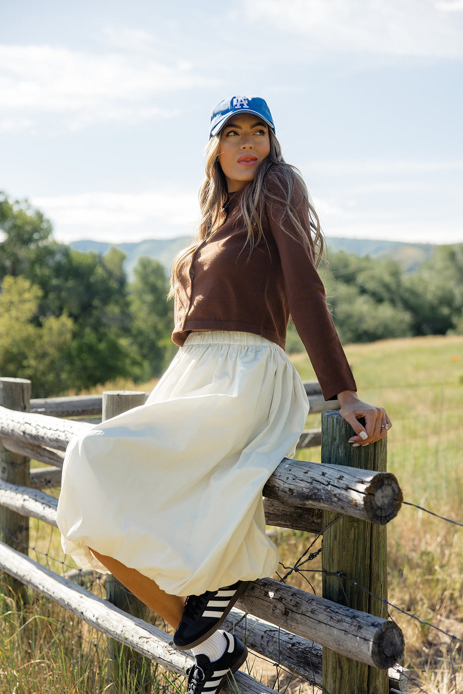 a woman leaning on a fence