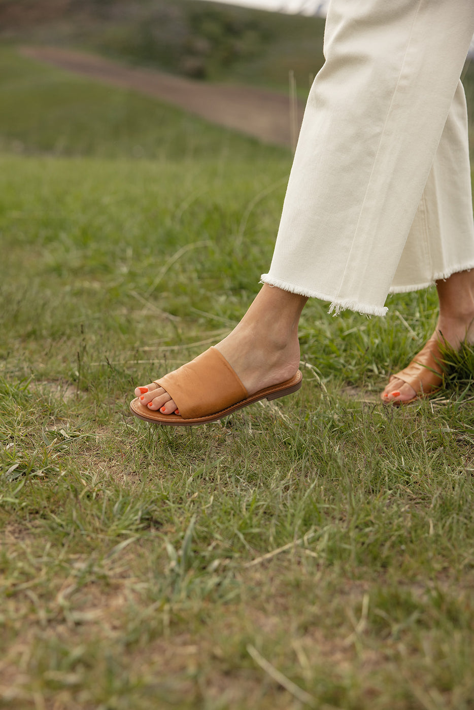 a person's feet in a grass field