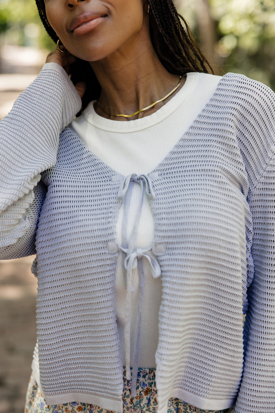 a woman wearing a white shirt and a blue sweater