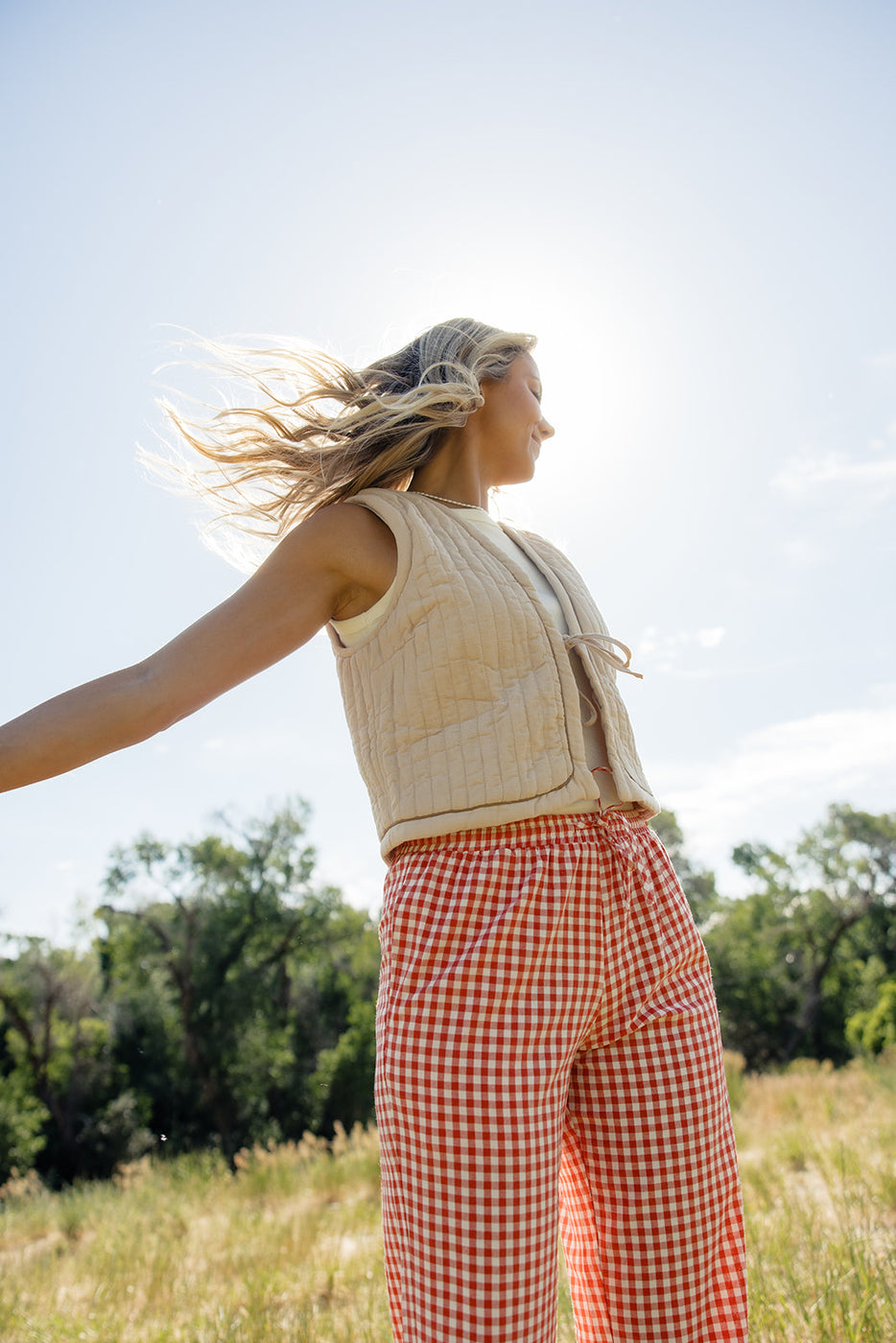 a woman with her arms outstretched outside