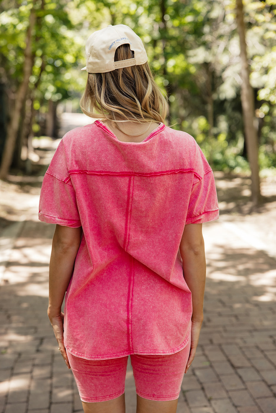 a woman wearing a pink shirt and hat