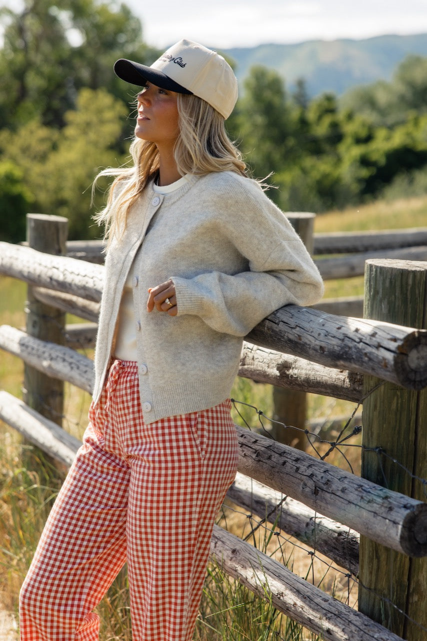 a woman leaning on a fence