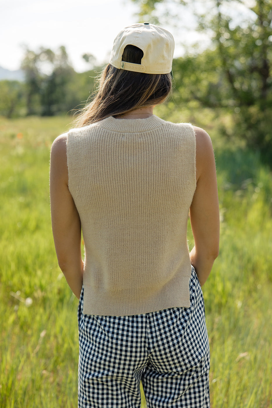 a woman in a hat standing in a field