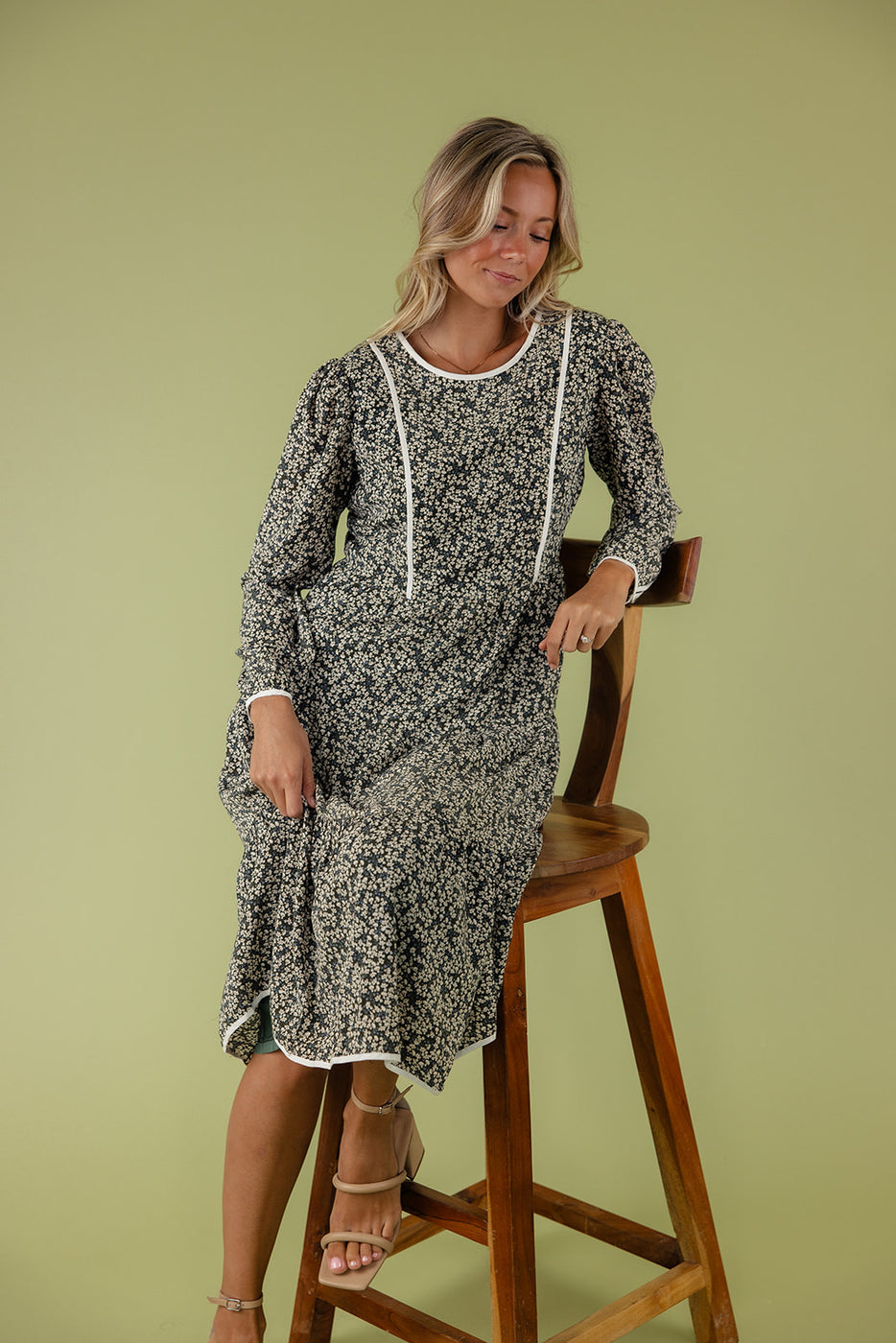 a woman in a floral dress sitting on a chair