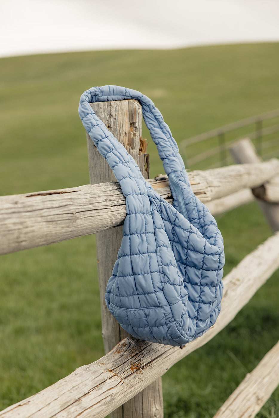 a blue bag on a wooden fence