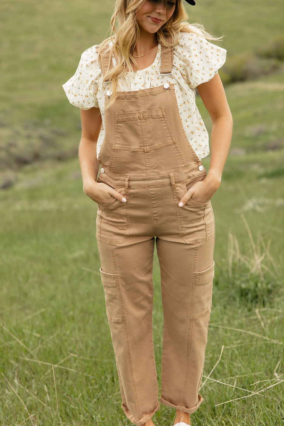 a woman in overalls standing in a field