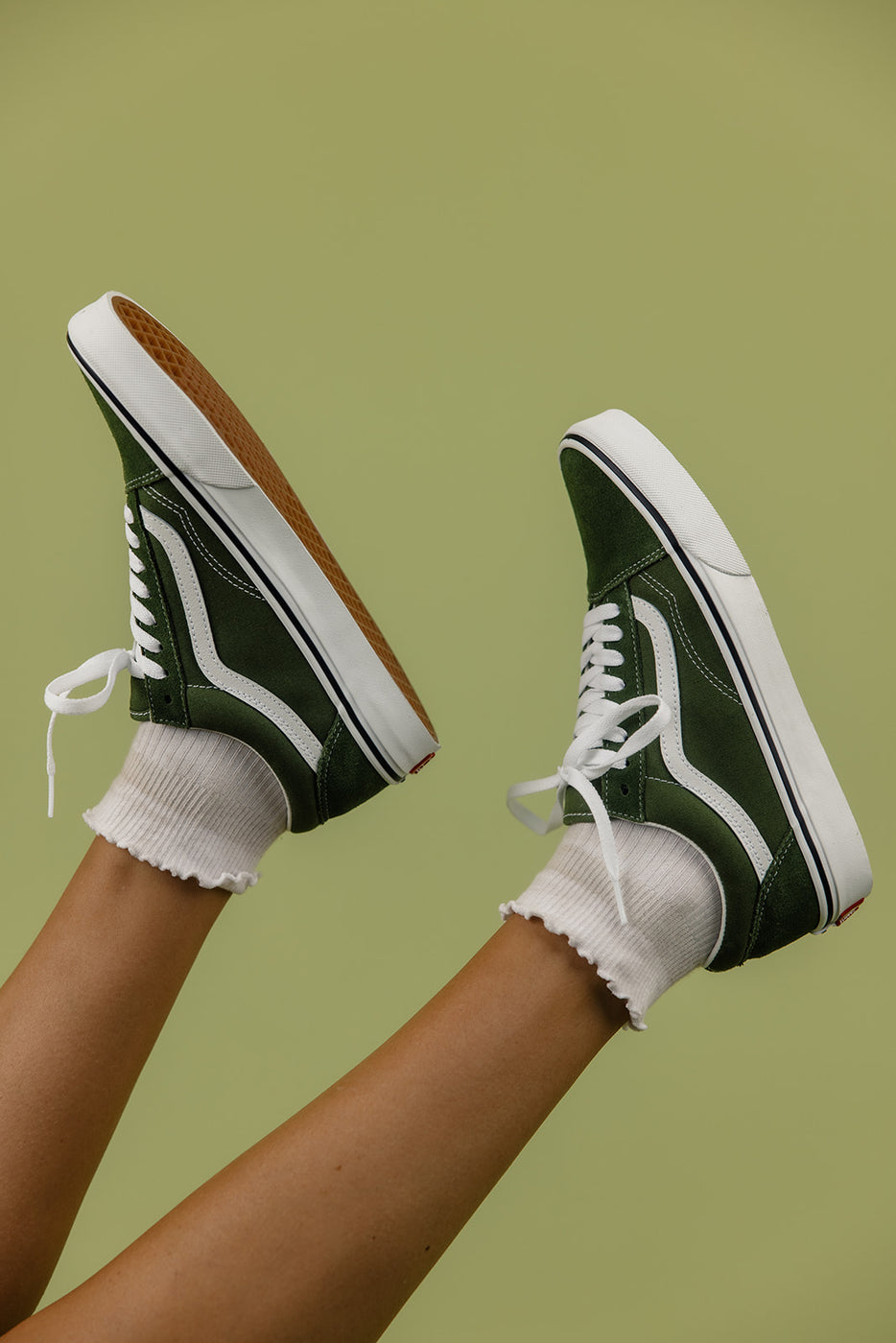 a pair of feet in green and white shoes