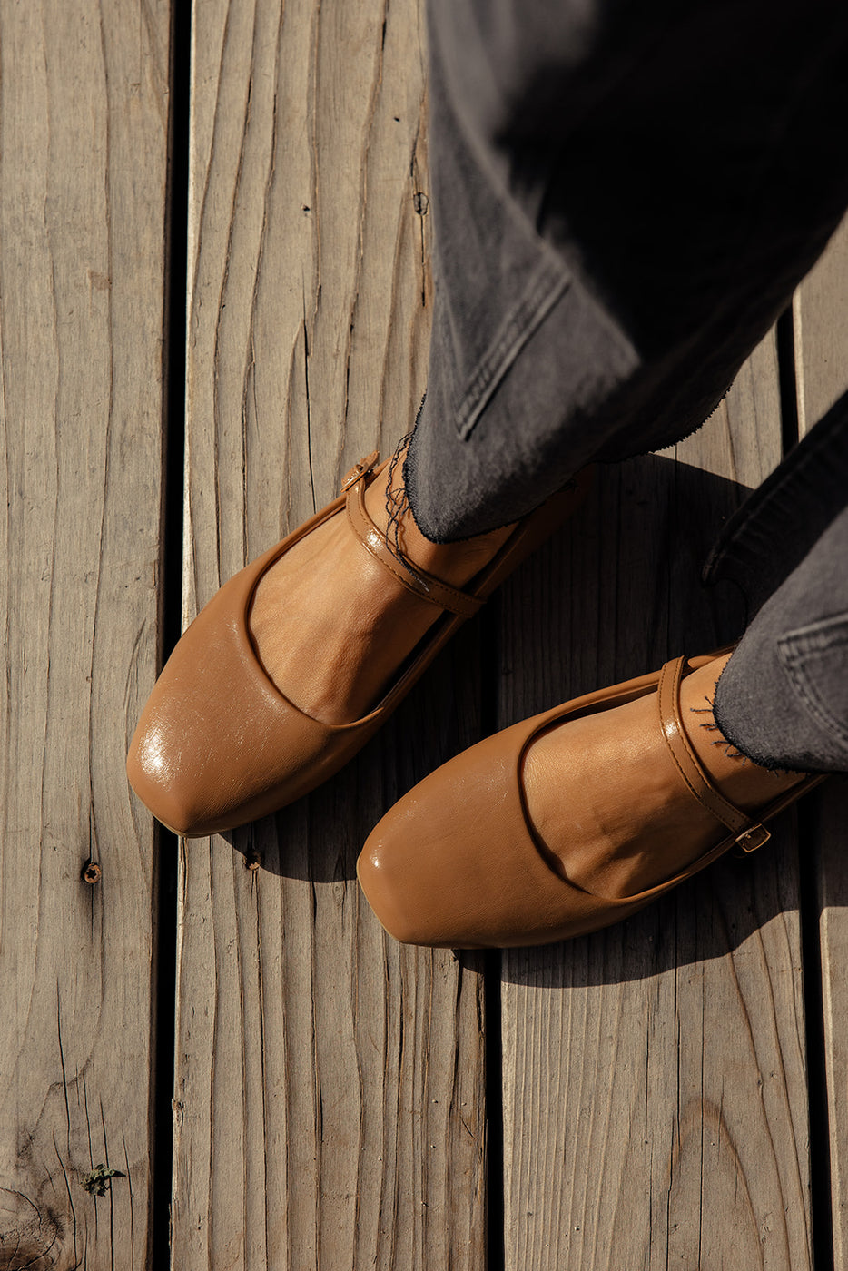 a person's feet wearing brown shoes