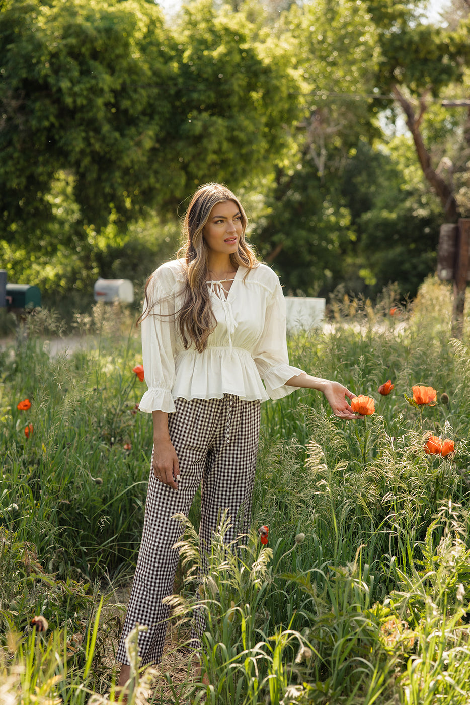 a woman standing in a field of flowers