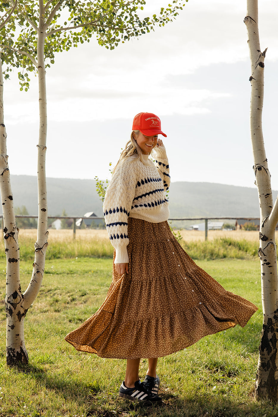 a woman wearing a red hat and a long skirt