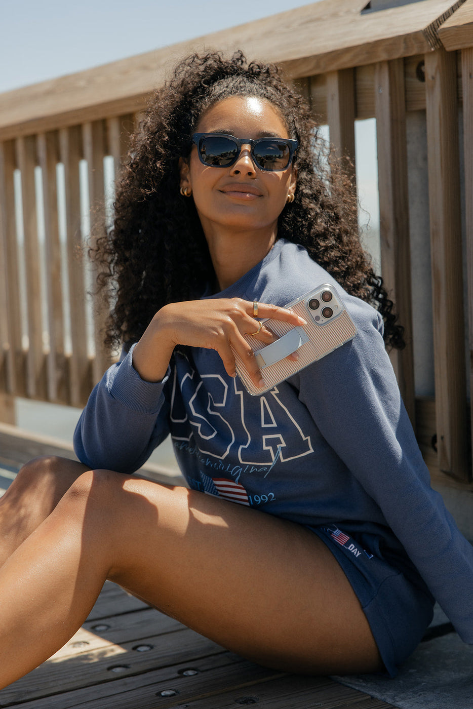 a woman sitting on a bench holding a phone