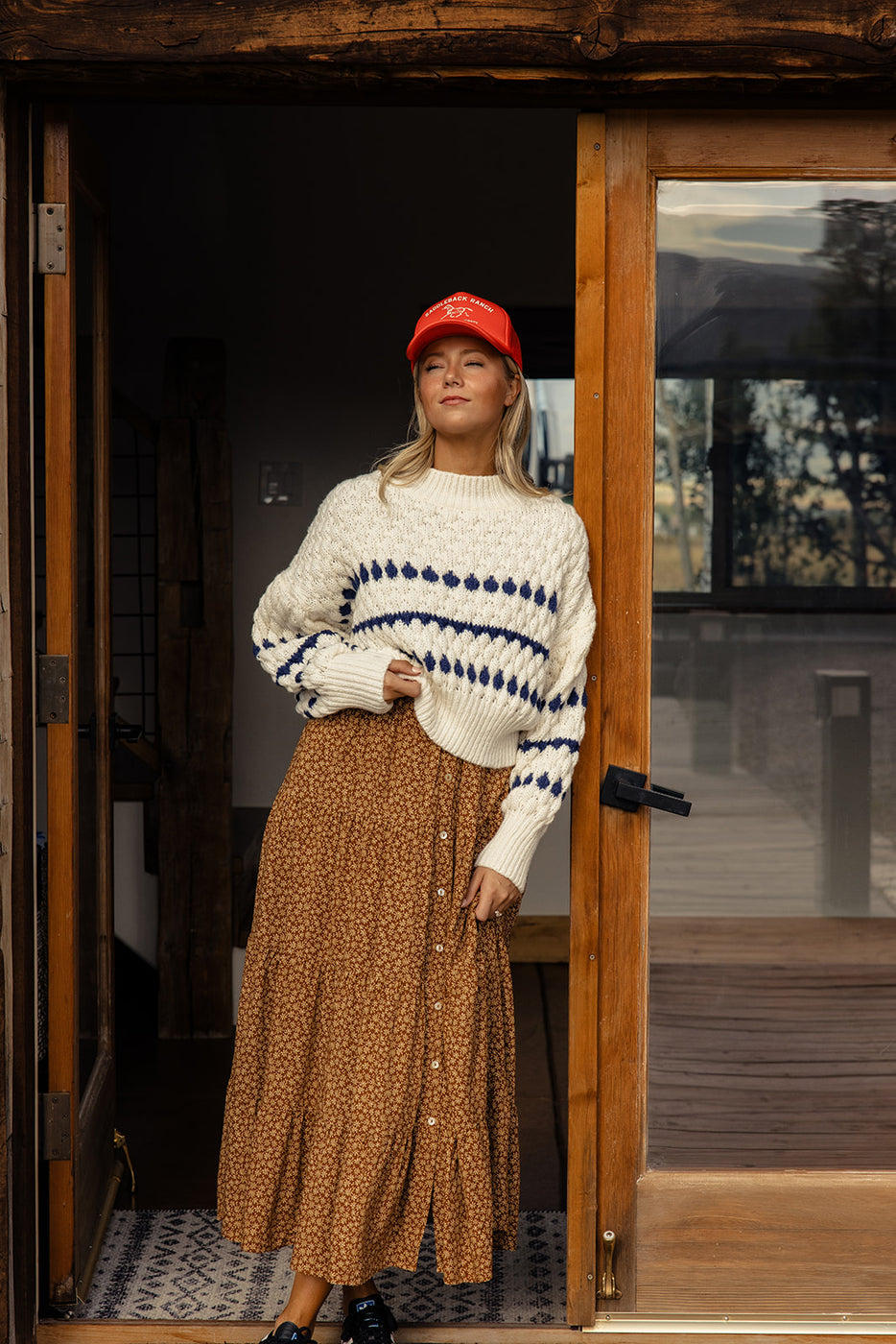 a woman in a long skirt and a white sweater