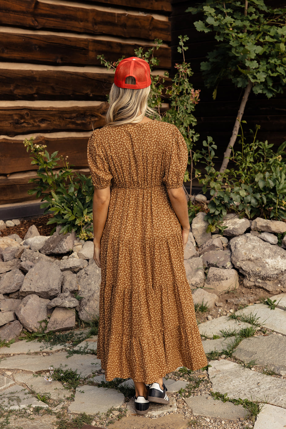 a woman wearing a brown dress and red hat