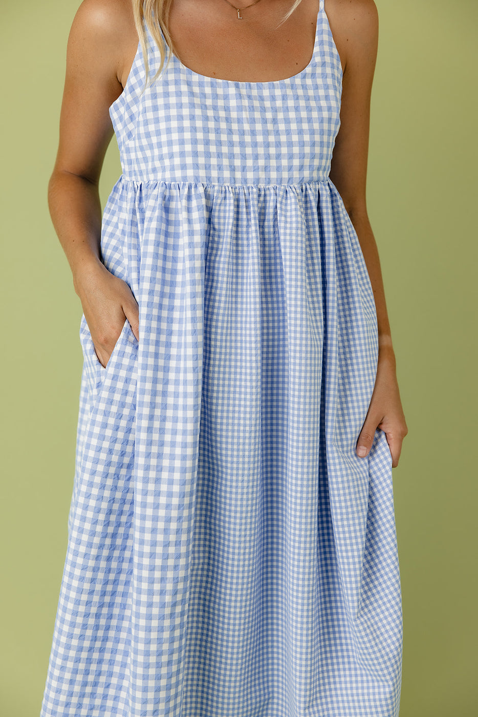 a woman wearing a blue and white checkered dress