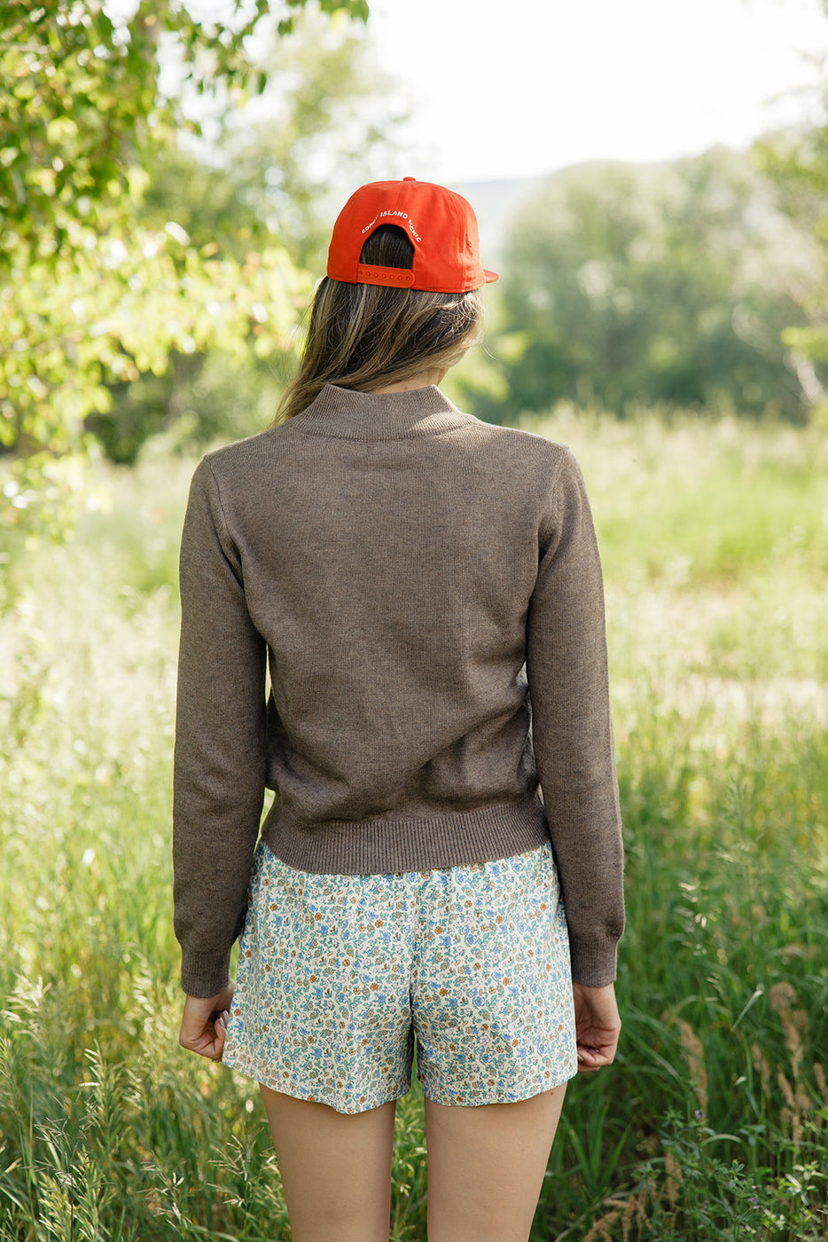 a woman wearing a red hat and a brown sweater