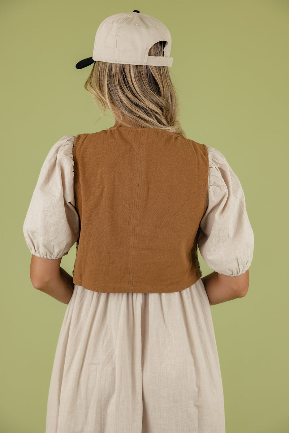 a woman in a brown vest