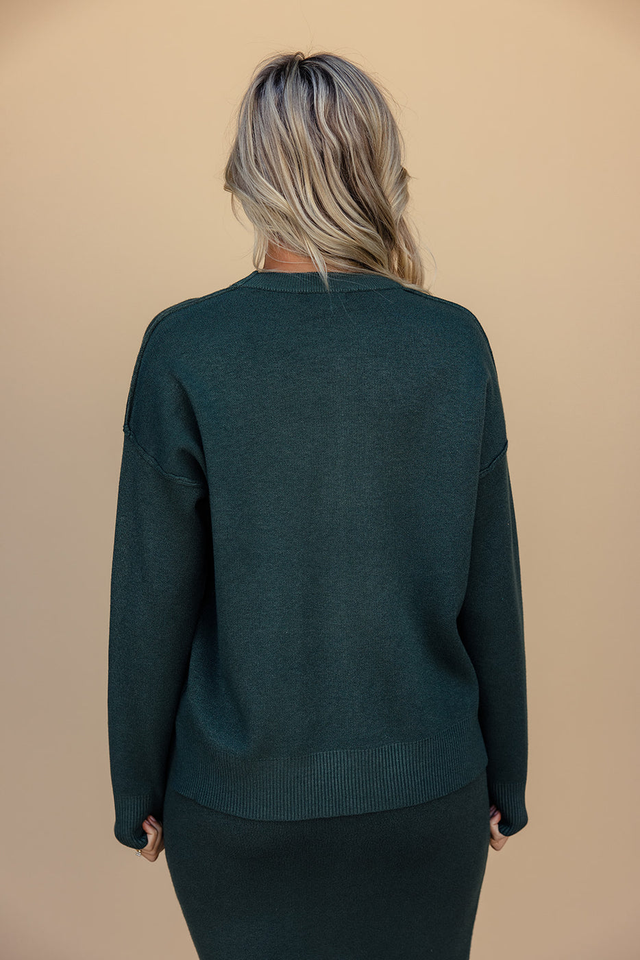 a woman wearing a green sweater