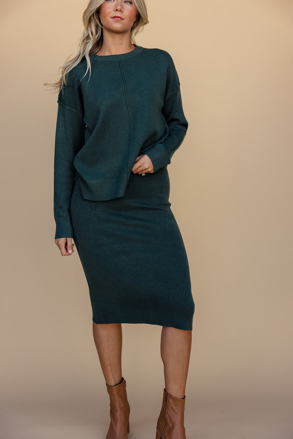 a woman in a green sweater and skirt