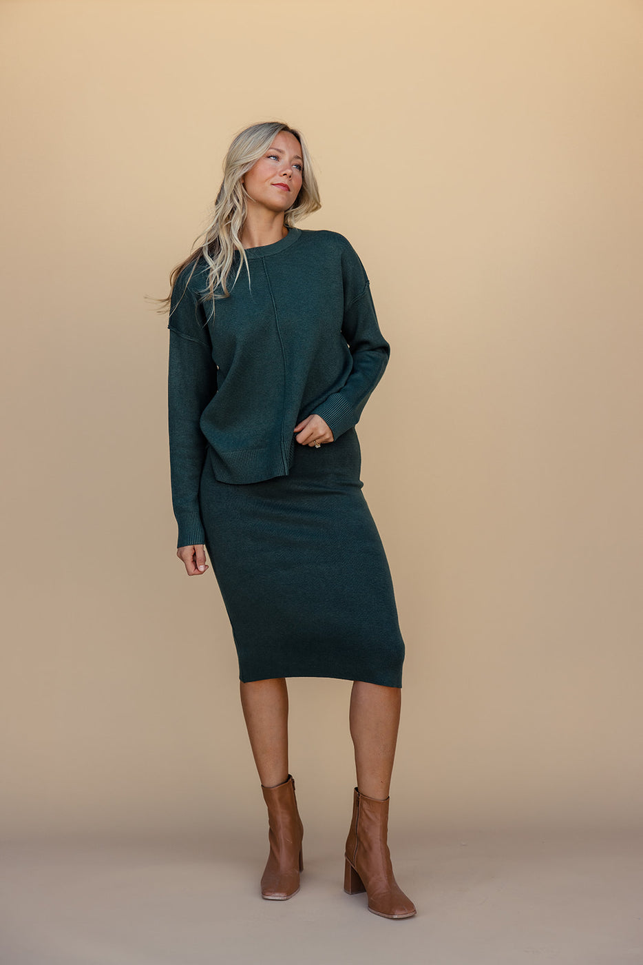 a woman in a green sweater and skirt