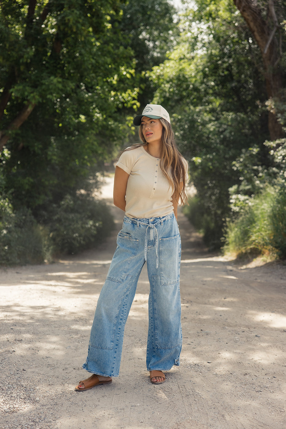 a woman standing on a dirt road