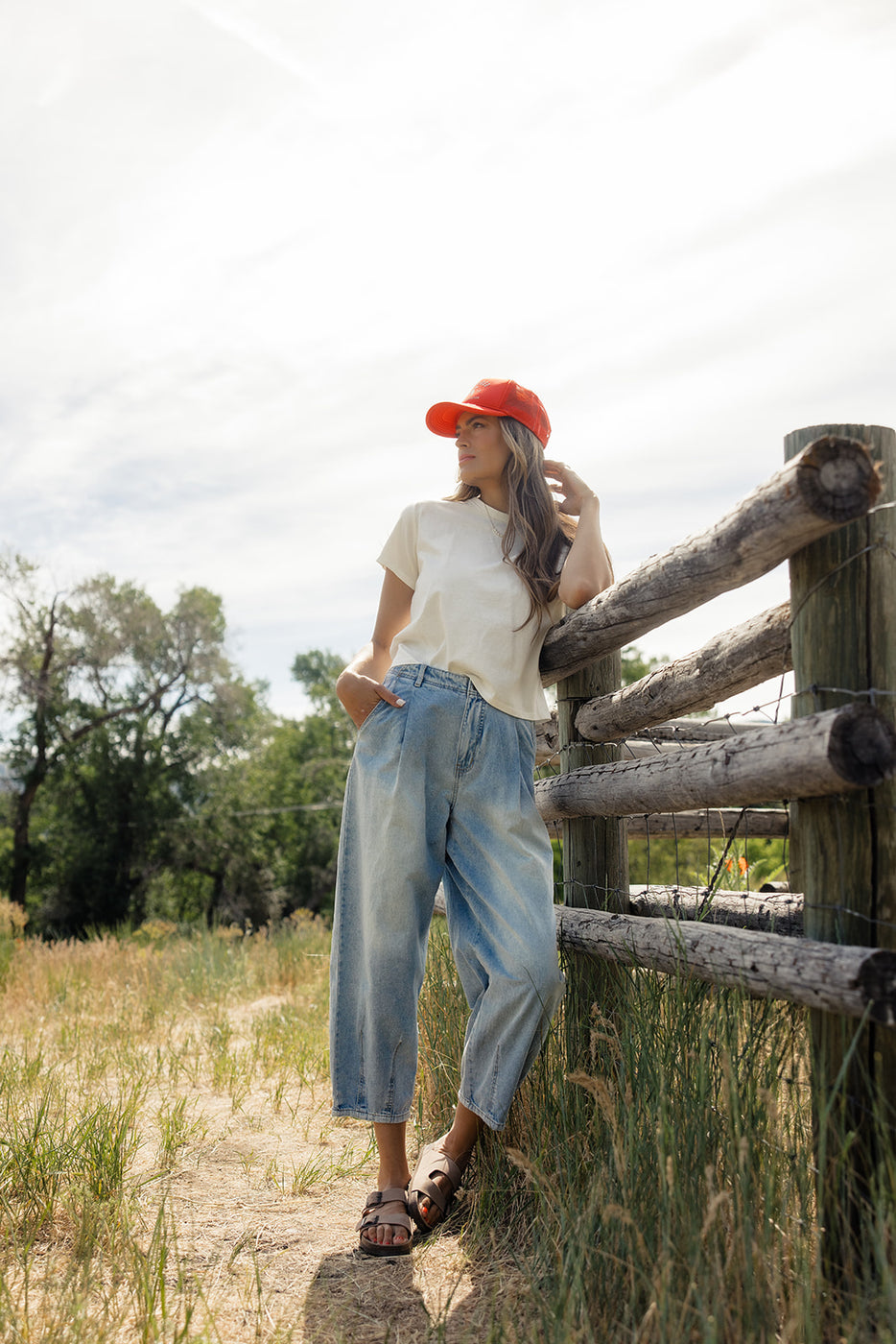 a woman leaning against a fence