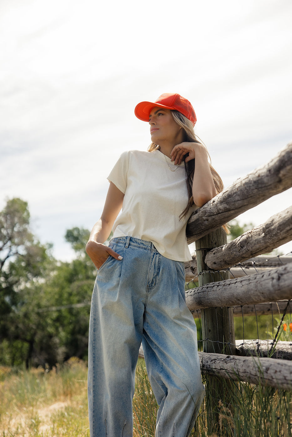 a woman leaning on a wooden fence