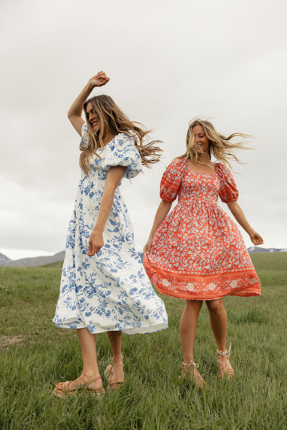 two women in dresses in a field
