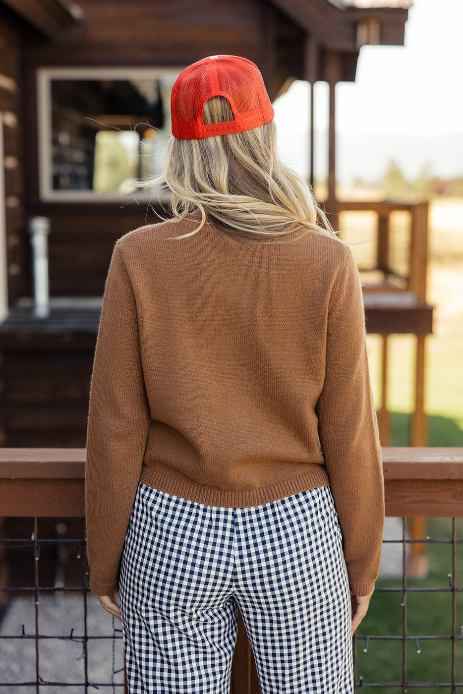 a woman wearing a red hat and brown sweater