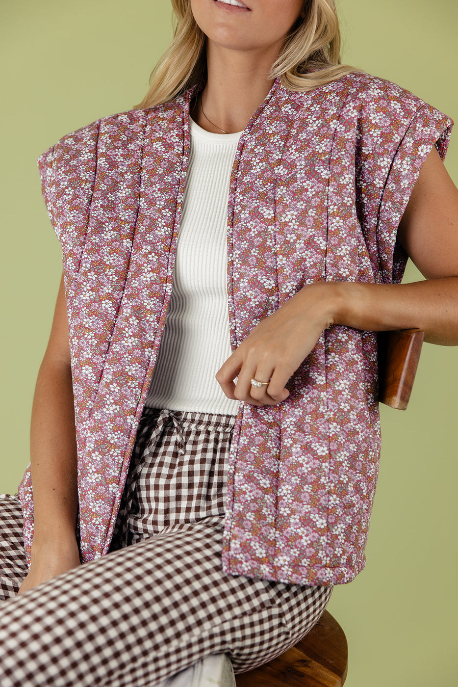 a woman wearing a floral vest