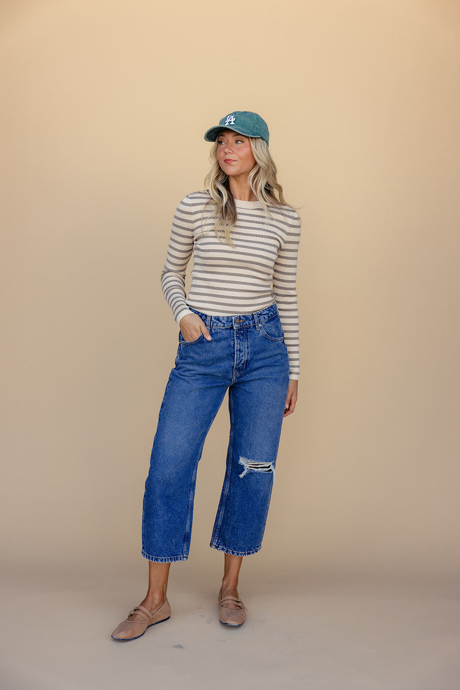 a woman wearing a hat and jeans