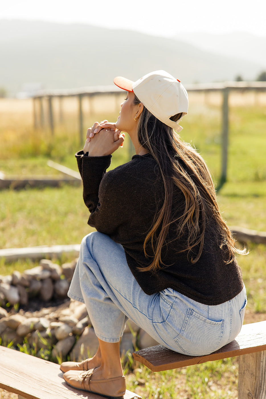 a woman sitting on a bench looking up