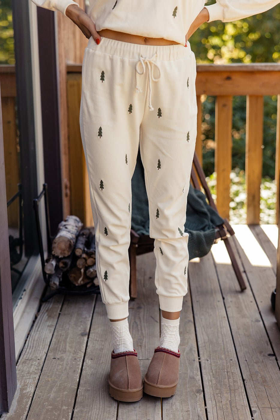 a person wearing white pants with green trees on them