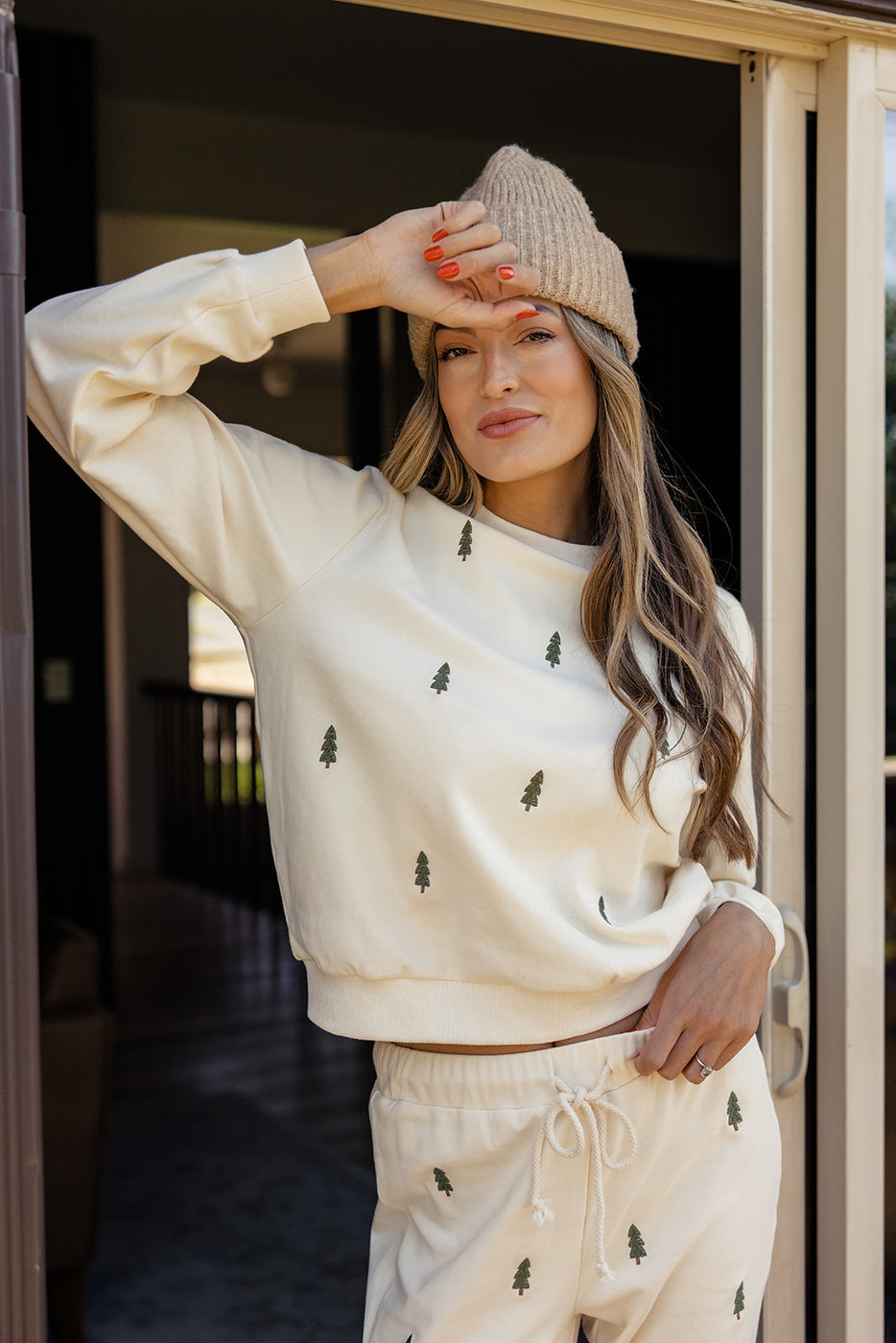 a woman wearing a white sweater and hat