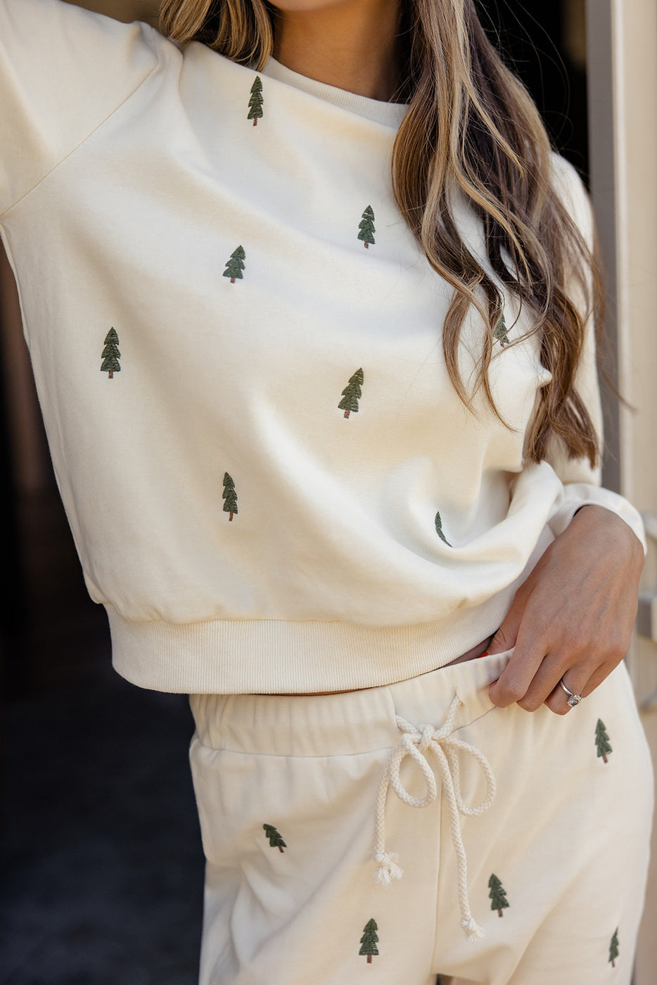 a woman wearing a white sweater and pants