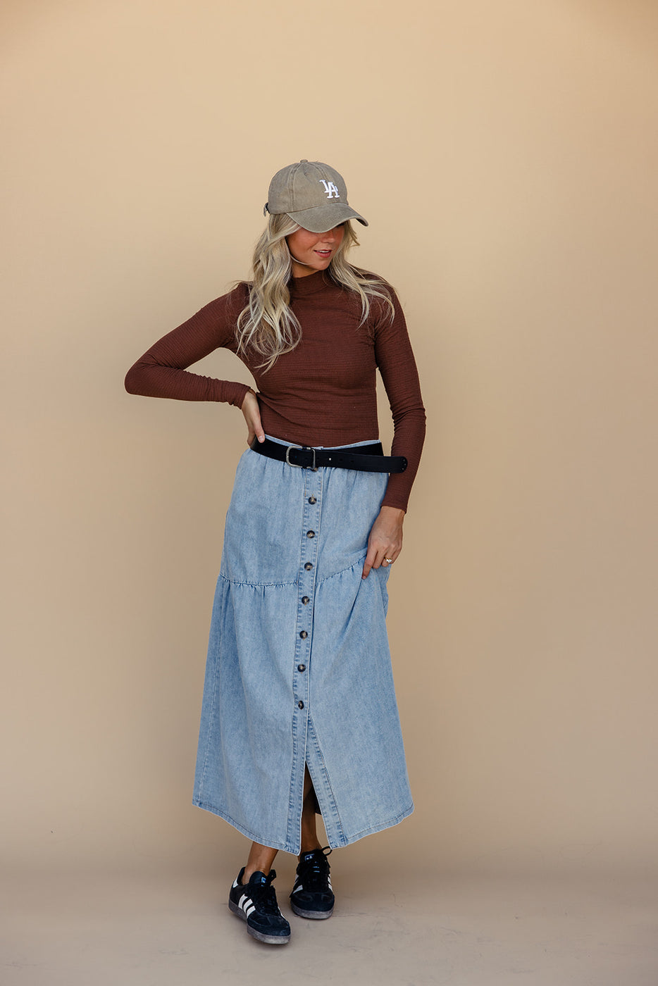 a woman in a long blue skirt and a brown shirt