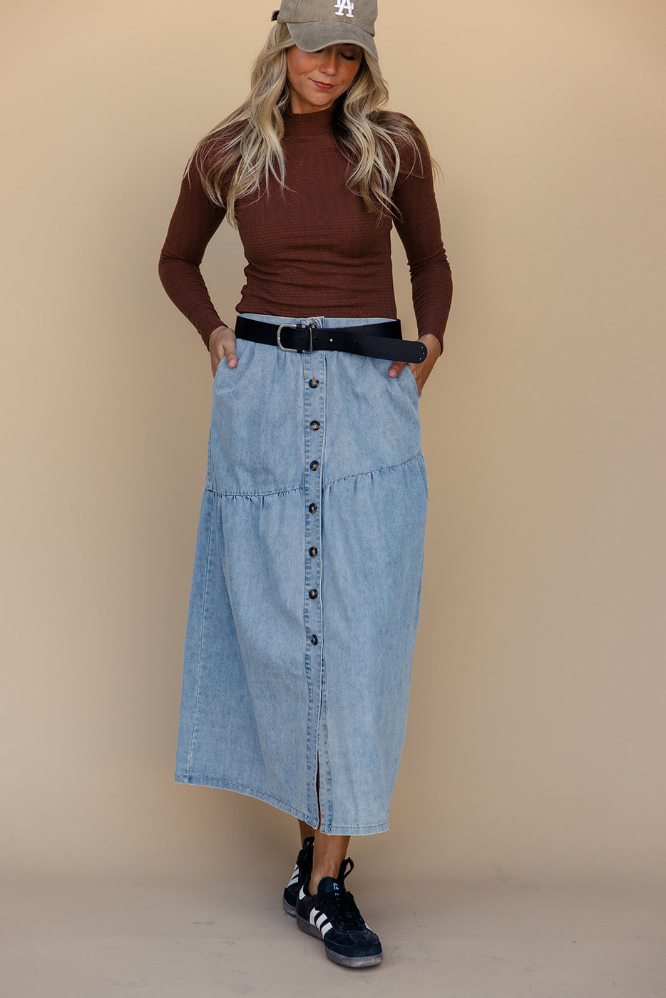 a woman in a long blue skirt and brown shirt