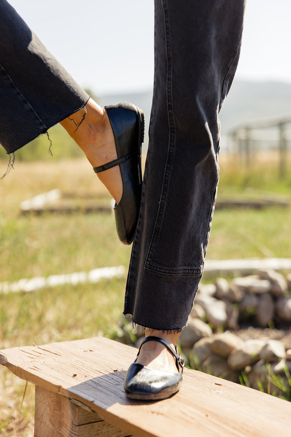 a person's feet in black shoes