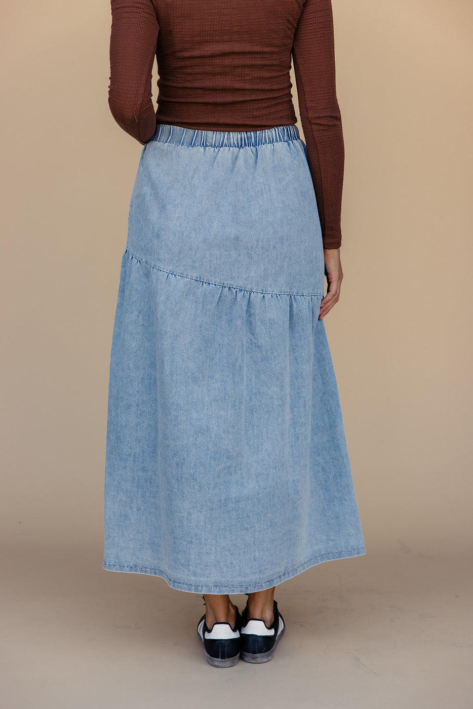 a woman wearing a blue denim skirt