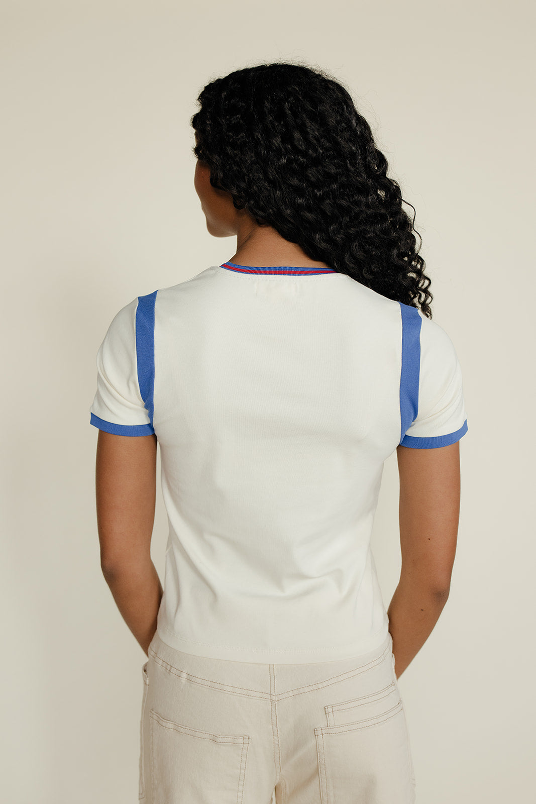 Woman wearing a blue and white tee against a white background