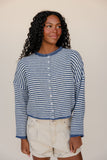 Woman wearing a blue and white striped shirt against a plain background